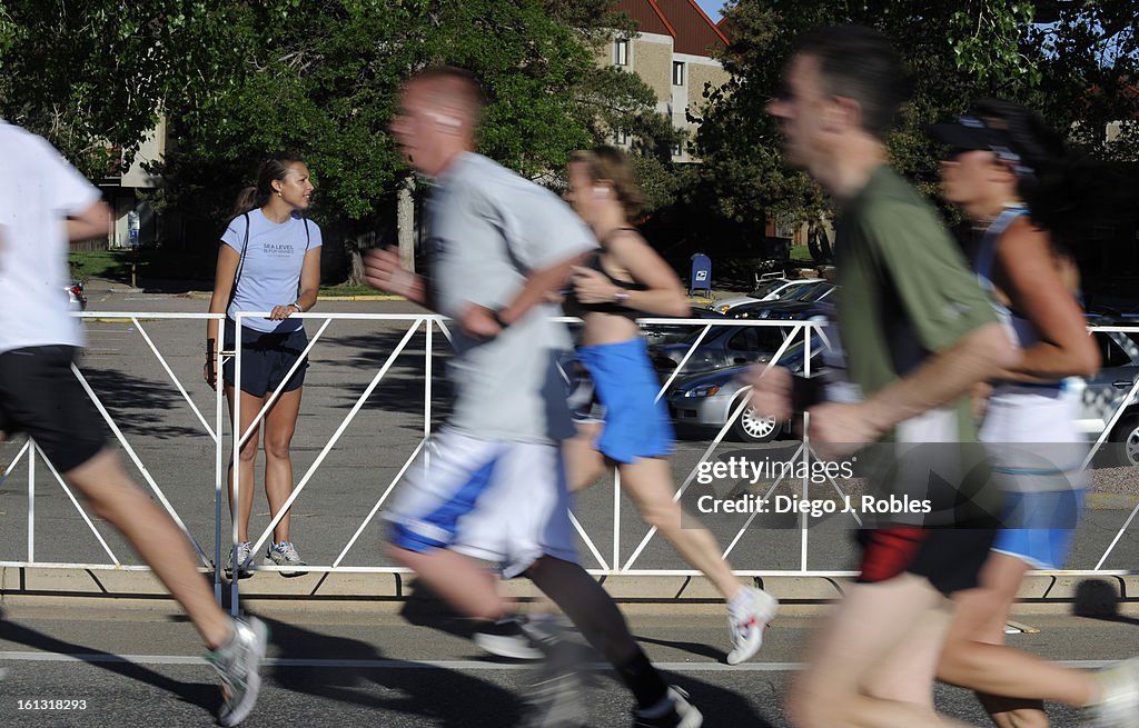 The cross country coach at Niwot High School in Boulder, Angelina Ramos waits for her athletes to pass by during Bolder Boulder 10k Race on Monday morning, May 31, 2010. Diego James Robles, The Denver Post