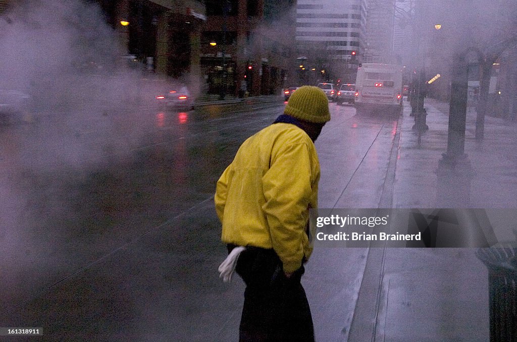 (bb) bncd03weather _bb_1 -- Downtown gets going to work under saturated skies and slick streets Thursday morning. ( Photo by Brian Brainerd / The Denver Post)
