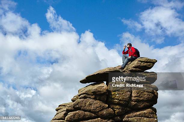 hiker on top of a rock - outdoor guy sitting on a rock stockfoto's en -beelden