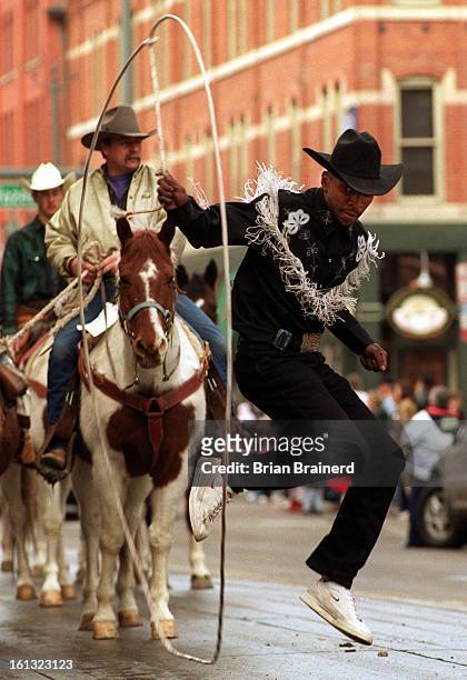 Trick roper Andre McClain does some fancy rope and foot work as he walks up 17th Street in the 2001 National Western Stock Show Parade Tuesday.
