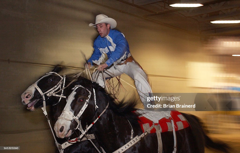 DENVER, CO, JAN 18, 2004 -- Stay with 'em! -- Trick rider, Shawn Brackett <cq>, 25, of Collinsville, OK, rides into the Great American Wild West Show through a portal in the National Western Events Center Sunday afternoon. Known as Roman Riding, he rides 