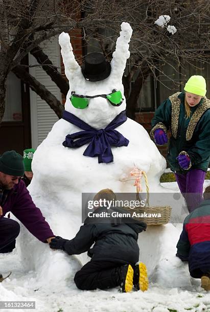 Daniel Einarsen, left, and neighbor, Geg Kritenbrink, center, and Einarsen's daughter, Amy, work on a snow bunny Wednesday in front of their...