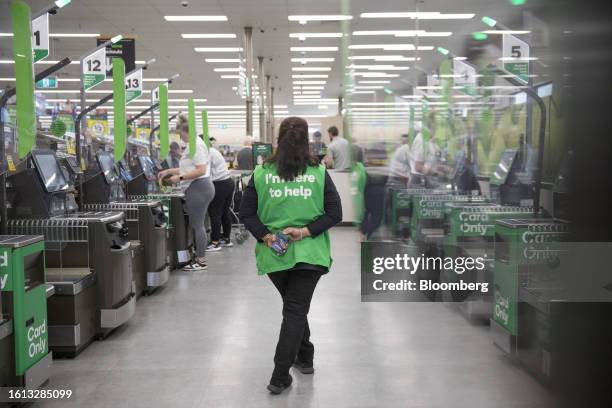 An employee supervises self-service checkout kiosks at a Woolworths Group Ltd. Grocery store in Sydney, Australia, on Monday, Aug. 21, 2023....