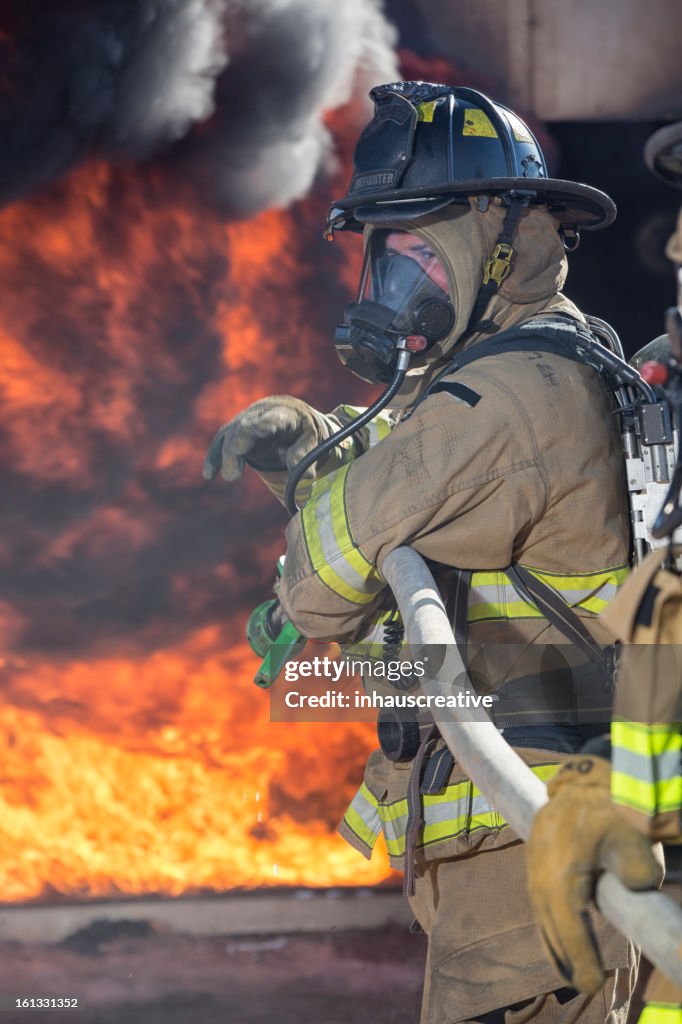 Firefighter ready to spray water