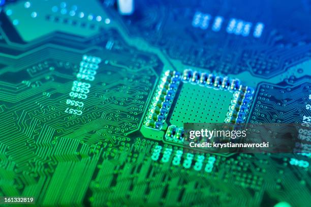 a closeup of a green and blue computer circuit board - mother board stock pictures, royalty-free photos & images