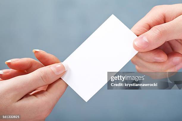 man giving women blank business card on gray background - passing giving 個照片及圖片檔