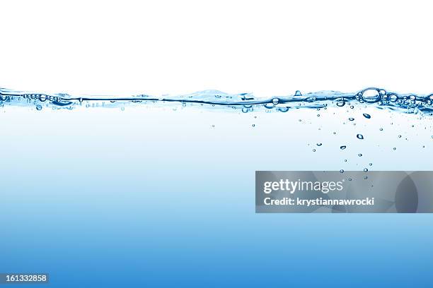 calm blue water surface with bubbles seen at low angle - wateroppervlak stockfoto's en -beelden