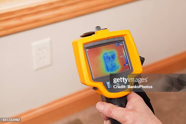 infrared thermal imaging camera pointing to wall outlet - temperature sensor stock pictures, royalty-free photos & images