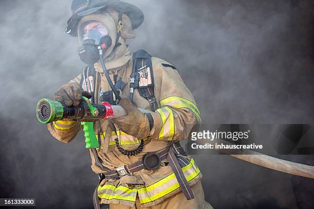 firefighter ready to spray water - brandslang stockfoto's en -beelden