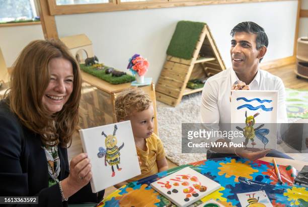 Prime Minister Rishi Sunak and Education Secretary Gillian Keegan hold images of bees they created during a visit to the Busy Bees nursery in...