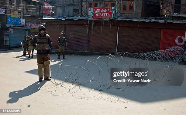 Indian paramilitary soliders stand guard during a curfew on the second consecutive day after the execution of Indian parliament convict Mohammad...