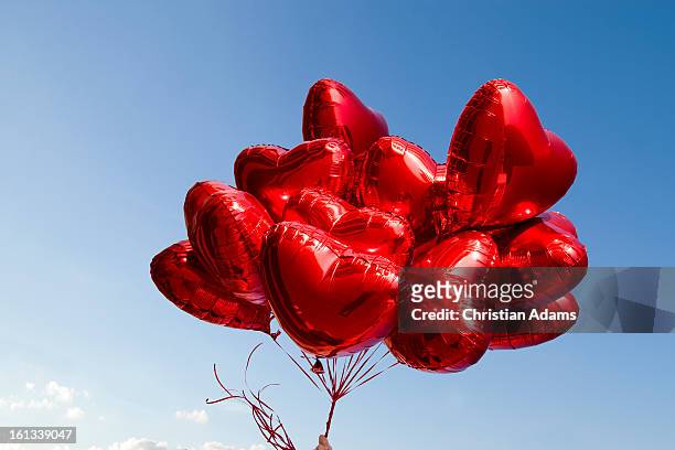 a bunch of red heart-shaped balloons - adoreren stockfoto's en -beelden