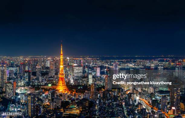 tokyo tower and crowded skyscrapers in tokyo japan at night. - tokyo toranomon hills stock pictures, royalty-free photos & images