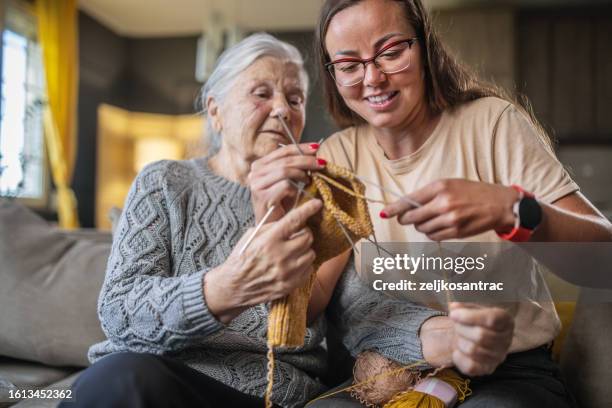 grandmother teaching granddaughter knitting - granddaughter stock pictures, royalty-free photos & images
