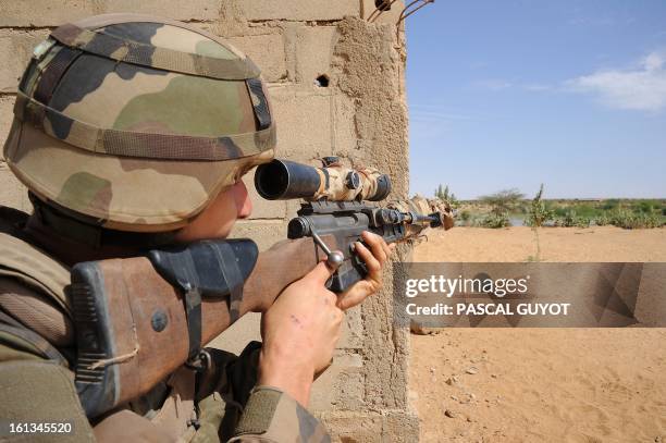 French sniper is on duty as French soldiers patrol at the site where a suicide bomber blew himself up on February 10, 2013 in northern Gao on the...