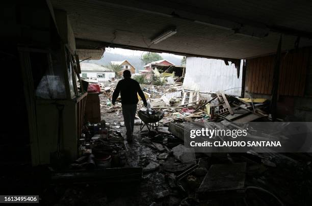 Man walks inside a house in the Chilean city of Dichato, some 30 km from Concepcion on March 1, 2010 three days after a tsunami hit the city...