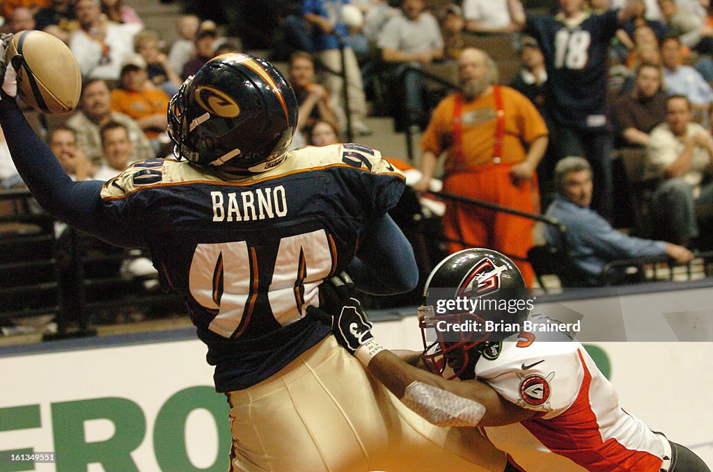 DENVER, CO, APR 3, 2005 -- <cq>Colorado Crush v. Las Vegas Gladiators Sunday at Pepsi Center. Dustin Barno pulls in a 4th period touchdown asgainst defender Coco Blalock to put the Crush up 60-40 before the extra point. (Photo by Brian Brainerd)