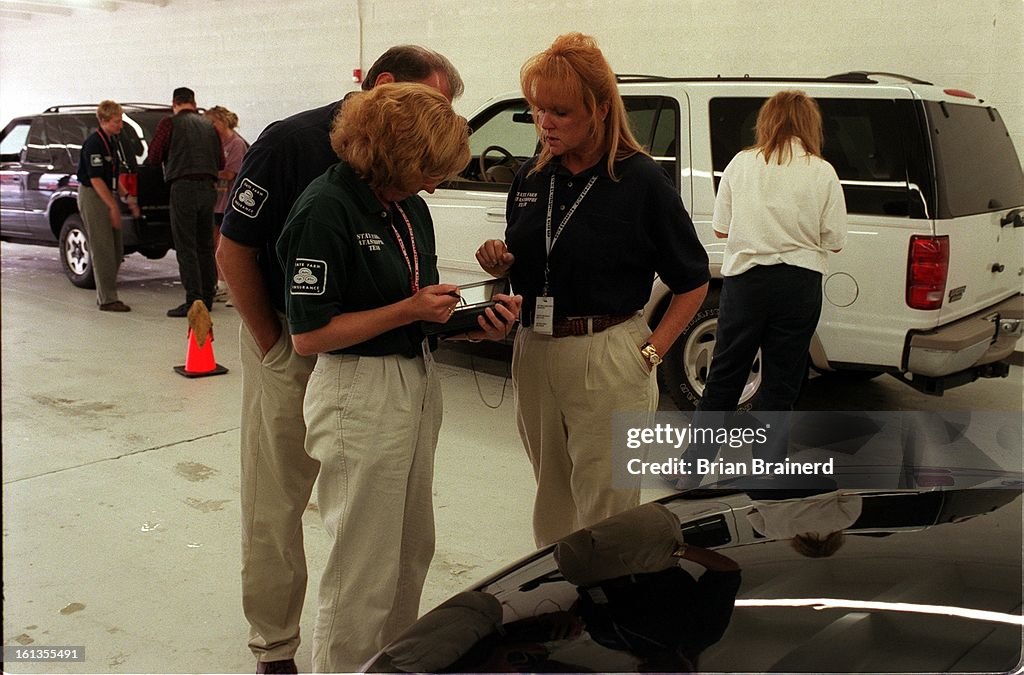 The State Farm Insurance disaster team on the scene at the Catastrophe Claim Center, 6090 W. 44th Ave. in Wheatridge estimating autos damaged by recent hail storms. Foreground left to right, Rich Lammert, Andrea Wallace and Becky Perkins estimate a vehicl