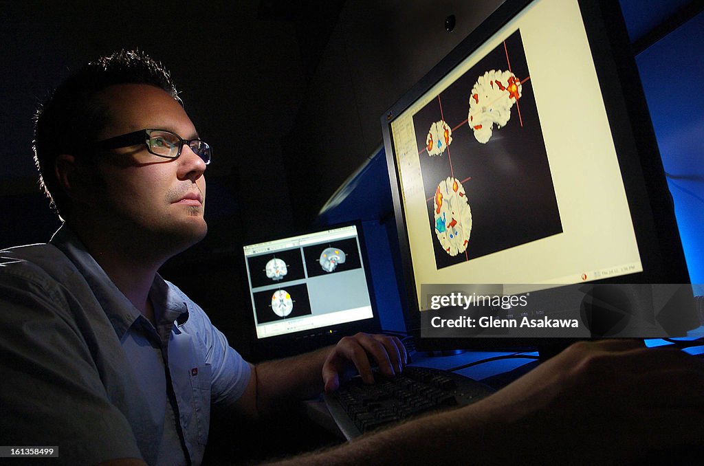 (ga) CDMEMORY--BOULDER, COLORADO--JULY 12, 2007 - University of Colorado doctoral candidate Brendan Depue <cq> looks over functional magnetic resonance images (FMRI) of the brain that highlight areas (in red) that control our cognitive behaviors and in hi