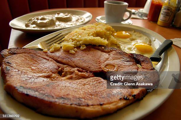 Massive country ham steak with fried eggs, biscuits and gravy is one of the signature breakfast items available at the Breakfast King restaurant at...