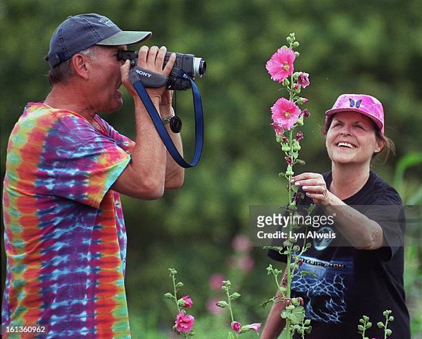 Steve and Nancy Seaver check out the pink hollyhock plant at the Denver Botanic Gardens' Community Garden . The couple are school teachers rom Miami,...