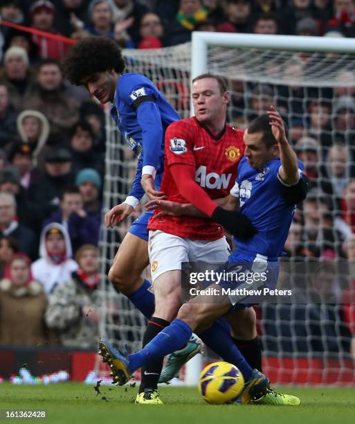 Wayne Rooney of Manchester United in action with Marouane Fellaini and Leon Osman of Everton during the Barclays Premier League match between...