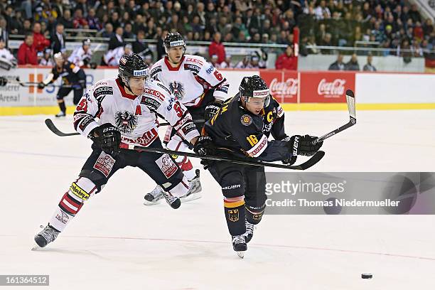 Michael Wolf of Germany fights for the puck with Matthias Trattnig of Austria during the Olympic Icehockey Qualifier match between Germany and...