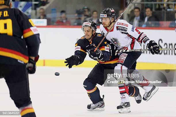 Benedikt Kohl of Germany fights for the puck with Thomas Raffl of Austria during the Olympic Icehockey Qualifier match between Germany and Austria on...