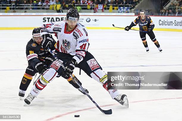 Michael Wolf of Germany fights for the puck with Mario Altmann of Austria during the Olympic Icehockey Qualifier match between Germany and Austria on...