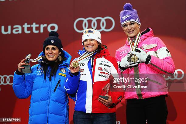 Race winner Marion Rolland of France celebrates at the medal ceremony with second placed Nadia Fanchini of Italy and third placed Maria Hoefl-Riesch...