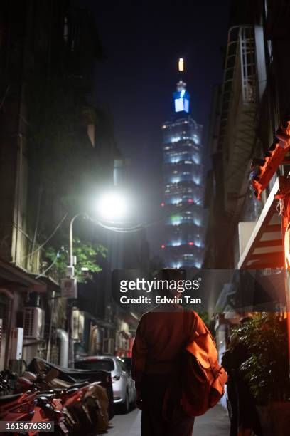 rear view asian chinese woman looking at taipei 101 from back alley at night - taiwan 101 stock pictures, royalty-free photos & images