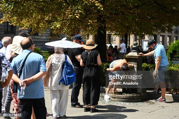 People line up at a fountain to drink water during a heatwave in Milan, Italy on August 21, 2023.