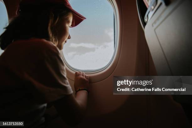 a young girl on a commercial plane - aterrizar fotografías e imágenes de stock