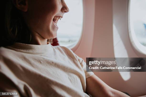 close-up of an excited child at a window seat on a plane - girl looking down stock pictures, royalty-free photos & images