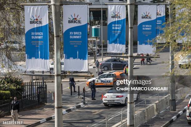 Johannesburg Metro Police Department officers direct traffic outside the Sandton Convention Centre ahead of the 2023 BRICS Summit in Johannesburg, on...