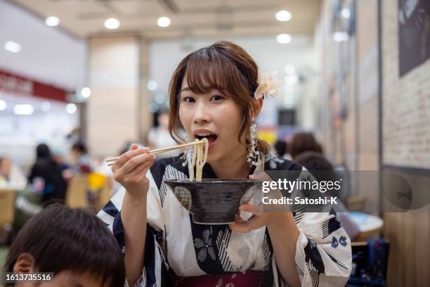 happy woman in yukata eating udon noodle - udon noodle stock pictures, royalty-free photos & images