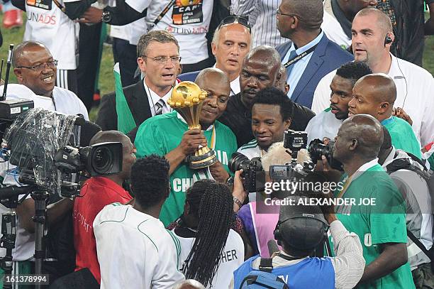 Nigeria's head coach Stephen Keshi poses with the trophy as he celebrates winning the 2013 African Cup of Nations final against Burkina Faso on...