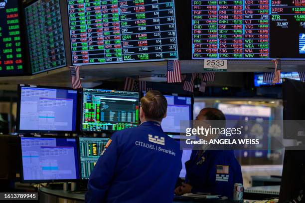 Traders work on the floor of the New York Stock Exchange during opening bell in New York City on August 21, 2023. European and US stocks rebounded on...