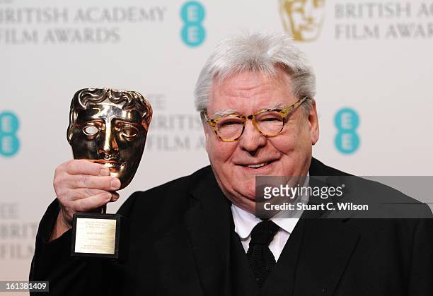 Sir Alan Parker, winner of the Fellowship award, poses in the press room at the EE British Academy Film Awards at The Royal Opera House on February...