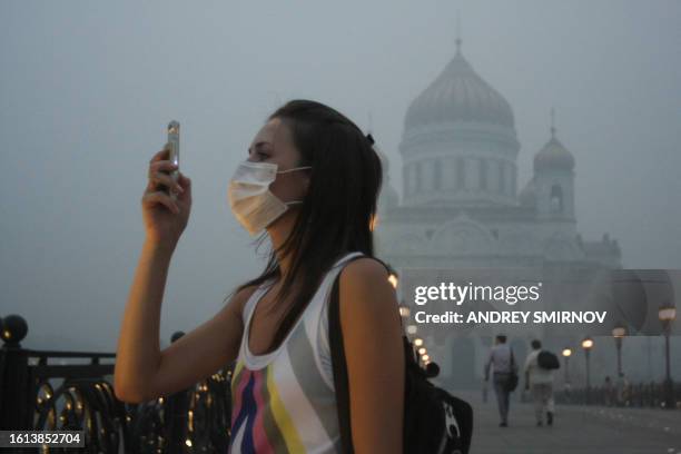 Russian girl wears a mask to protect herself from the forest fire smog in Moscow on August 4, 2010. Russia's worst heatwave for decades shows no sign...