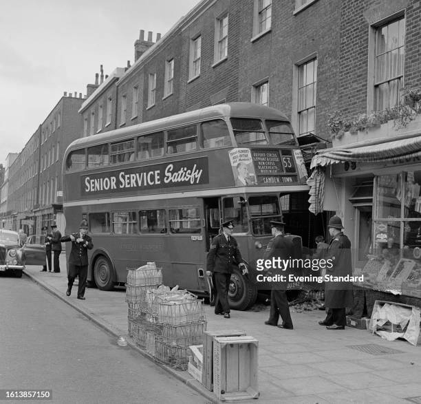Policemen investigate the bus crash at a grocery store in Albany Street, London, September 16th, 1957.