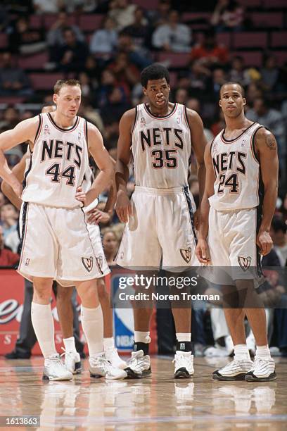 Three New Jersey Nets - forward Keith Van Horn, center Jason Collins, and forward Richard Jefferson - stand on the court during the NBA game against...