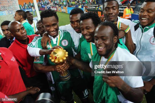 John Mikel Obi and Victor Moses lead celebrations with team mates with the trophy after winning the 2013 Africa Cup of Nations Final match between...