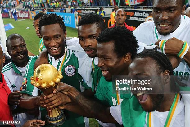 John Mikel Obi and Victor Moses lead celebrations with team mates with the trophy after winning the 2013 Africa Cup of Nations Final match between...