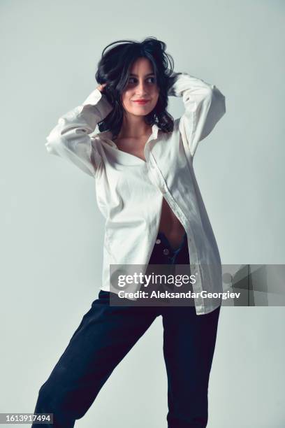 female beauty ruffling hair while wearing loose unbuttoned clothing - ruffling stock pictures, royalty-free photos & images
