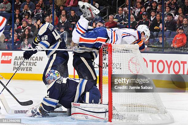 Taylor Hall of the Edmonton Oilers gets caught on the top of the net after goaltender Sergei Bobrovsky of the Columbus Blue Jackets makes a save in...
