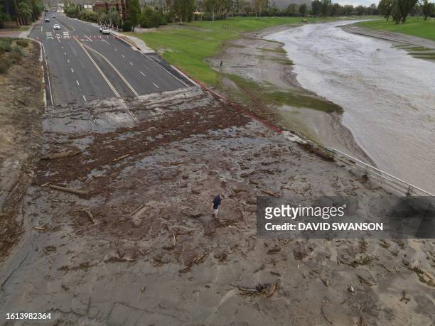 An aerial image shows a man surveying debris following heavy rains from Tropical Storm Hilary, at Thurderbird Country Club in Rancho Mirage,...