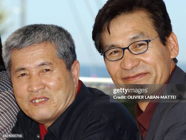 Korean director Im Kwon-Taek poses for photographers with actor Ahn Sung-Ki on a terrace of the palais des festivals during the photocall for their...