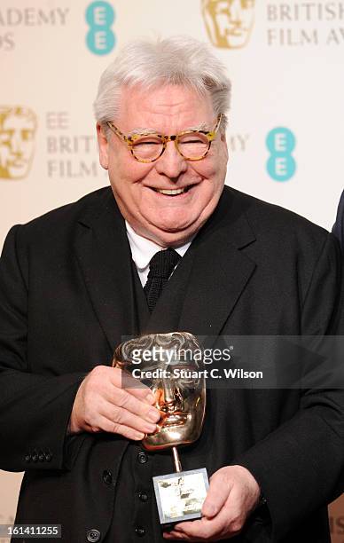 Sir Alan Parker, winner of the Fellowship award, poses in the press room at the EE British Academy Film Awards at The Royal Opera House on February...