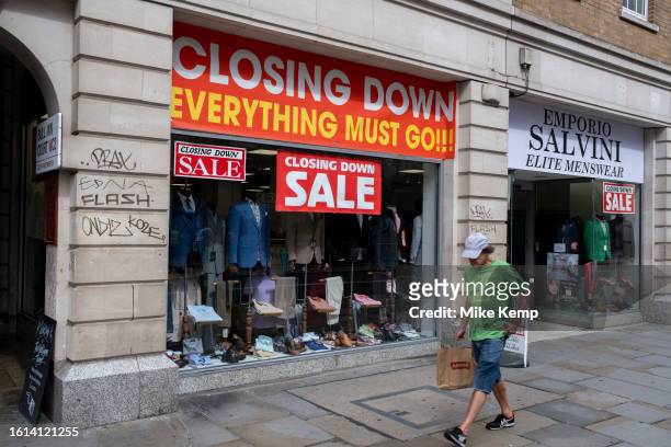 Suits and general menswear clothing are seen in the window of a retailer that is soon to close down and where sales bargains are to be had on 14th...
